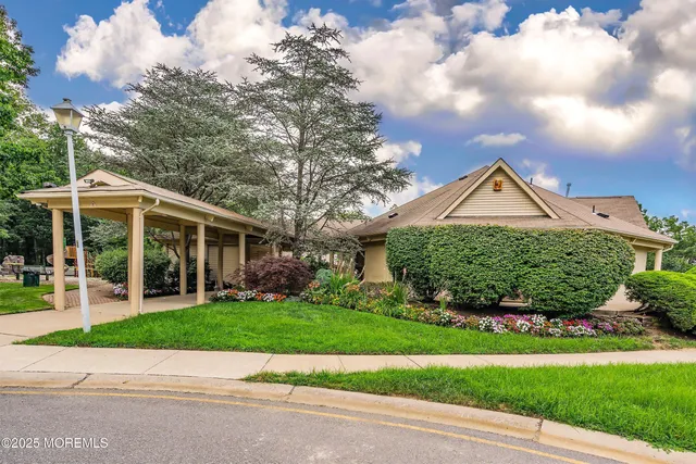 a front view of a house with a yard and potted plants
