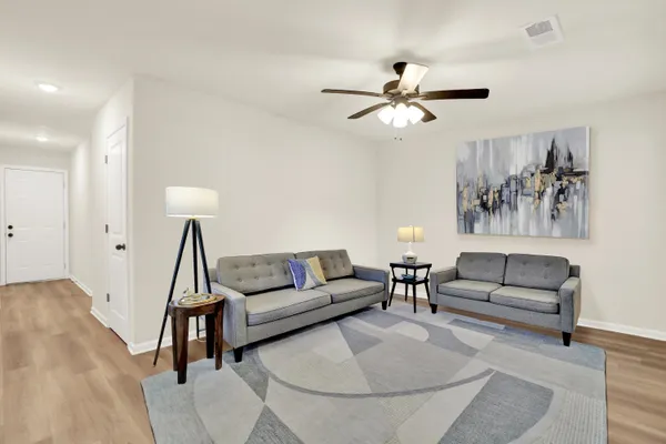 a living room with furniture and a wooden floor