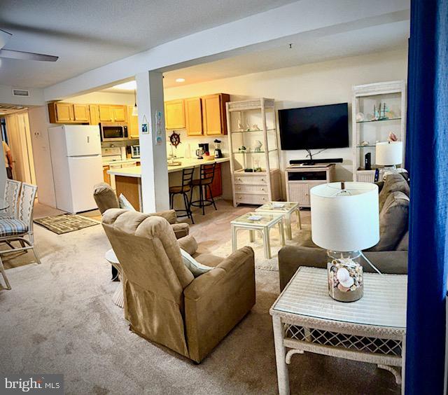 14401 Tunnel Avenue, Unit 262 Ocean City, MD 21842 - Photo 3 of 14 a living room with furniture a flat screen tv and a view of kitchen