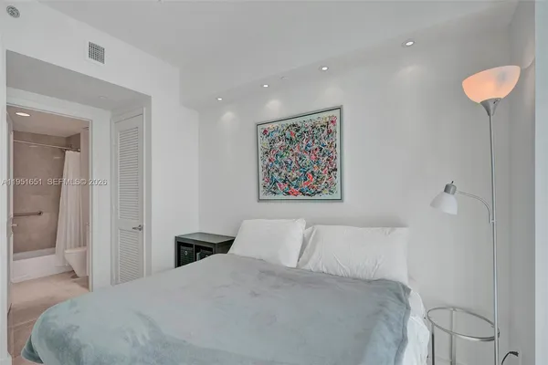 a bedroom with a bed and painting on the wall
