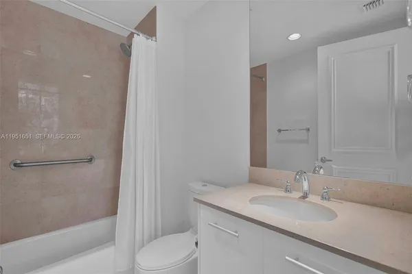 a bathroom with a granite countertop sink toilet and shower