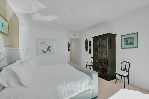 a bedroom with a bed and painting on the wall