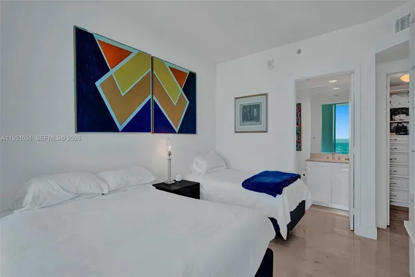 a bedroom with a bed and a lamp next to a window