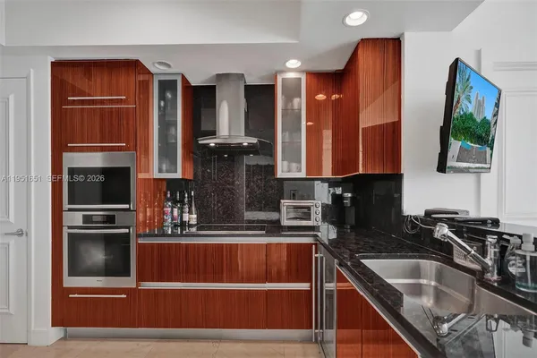 a kitchen with stainless steel appliances granite countertop a refrigerator and a sink