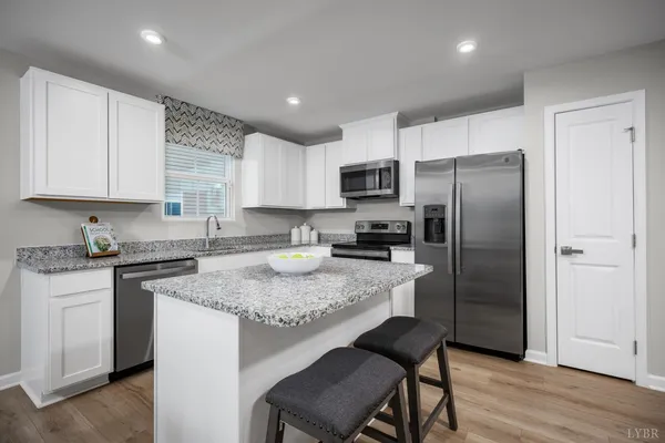 a kitchen with a refrigerator a stove a sink and cabinets