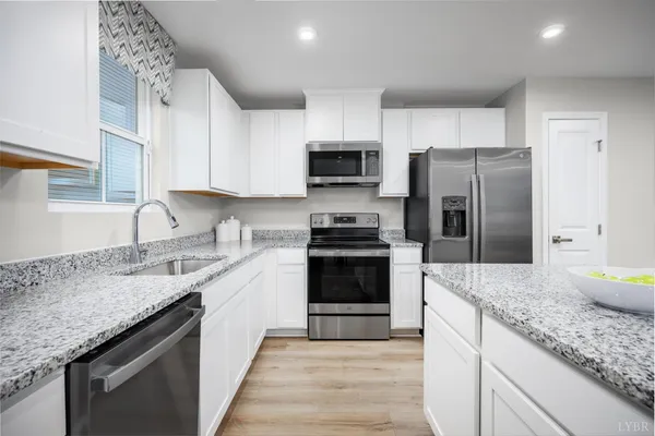 a kitchen with granite countertop a sink stove and refrigerator