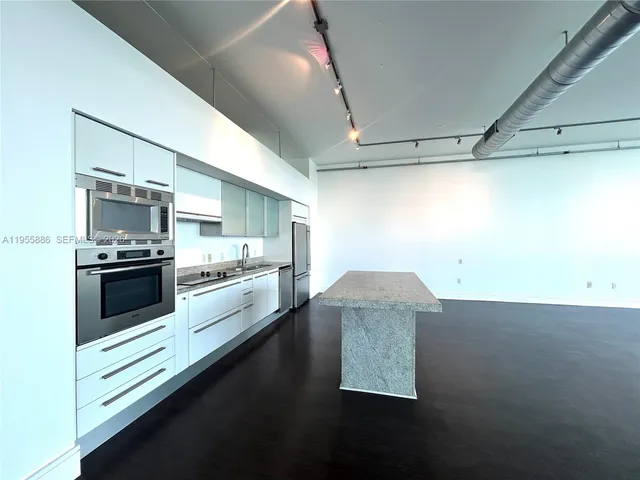 a large white kitchen with a stove and a refrigerator