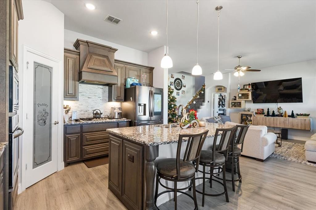 4209 Misty Ridge Street Mesquite, TX 75181 - Photo 40 of 40 a kitchen with stainless steel appliances kitchen island granite countertop a stove a sink a dining table and chairs