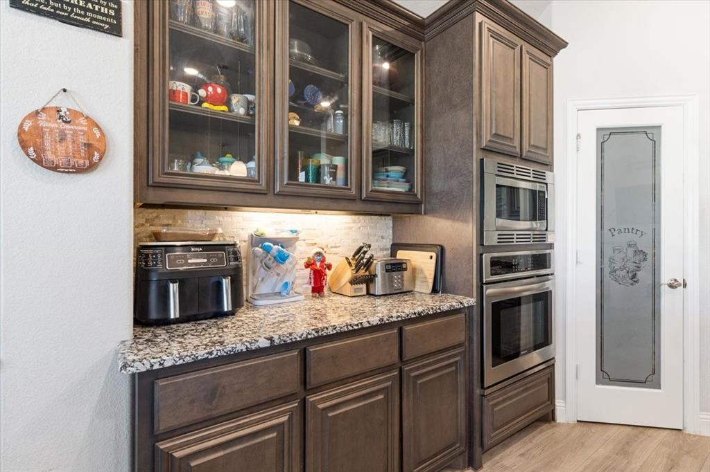 4209 Misty Ridge Street Mesquite, TX 75181 - Photo 20 of 40 a kitchen with stainless steel appliances granite countertop a stove and a microwave