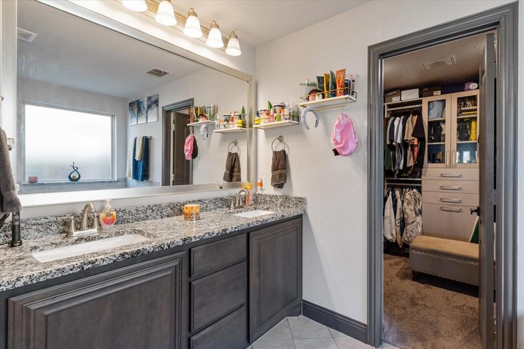 4209 Misty Ridge Street Mesquite, TX 75181 - Photo 28 of 40 a bathroom with a granite countertop sink and a mirror