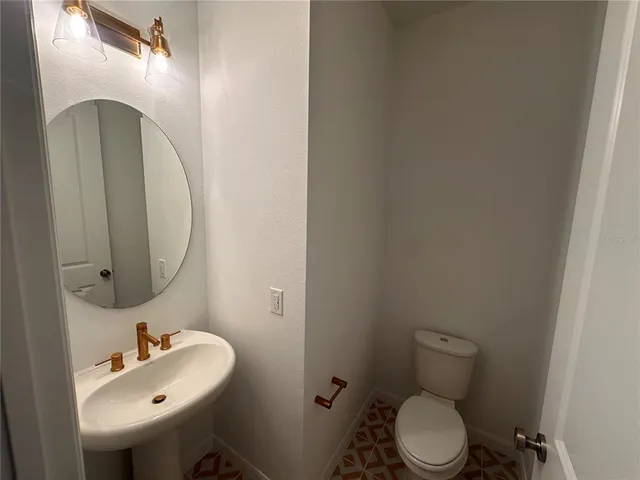 a bathroom with a sink mirror and toilet