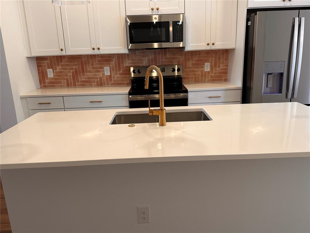 17592 Northlake Grv Drive Winter Garden, FL 34787 - Photo 7 of 14 a kitchen with granite countertop a refrigerator and a stove top oven