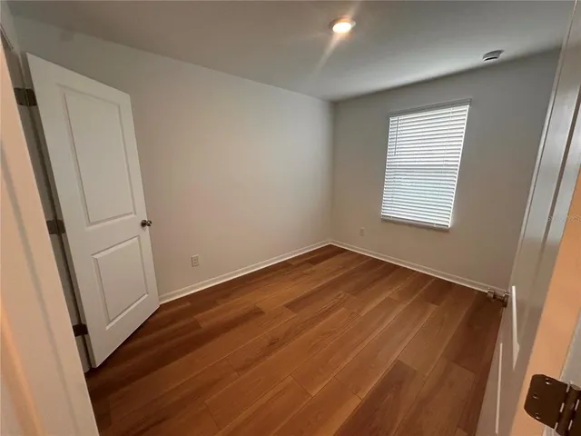 an empty room with wooden floor and window