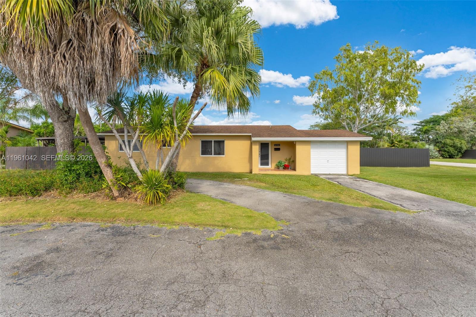 10901 Southwest 116th Street Miami, FL 33176 - Photo 4 of 26 a view of a house with a yard and palm trees