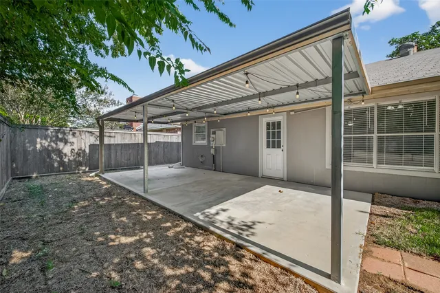 a backyard of a house with table and chairs
