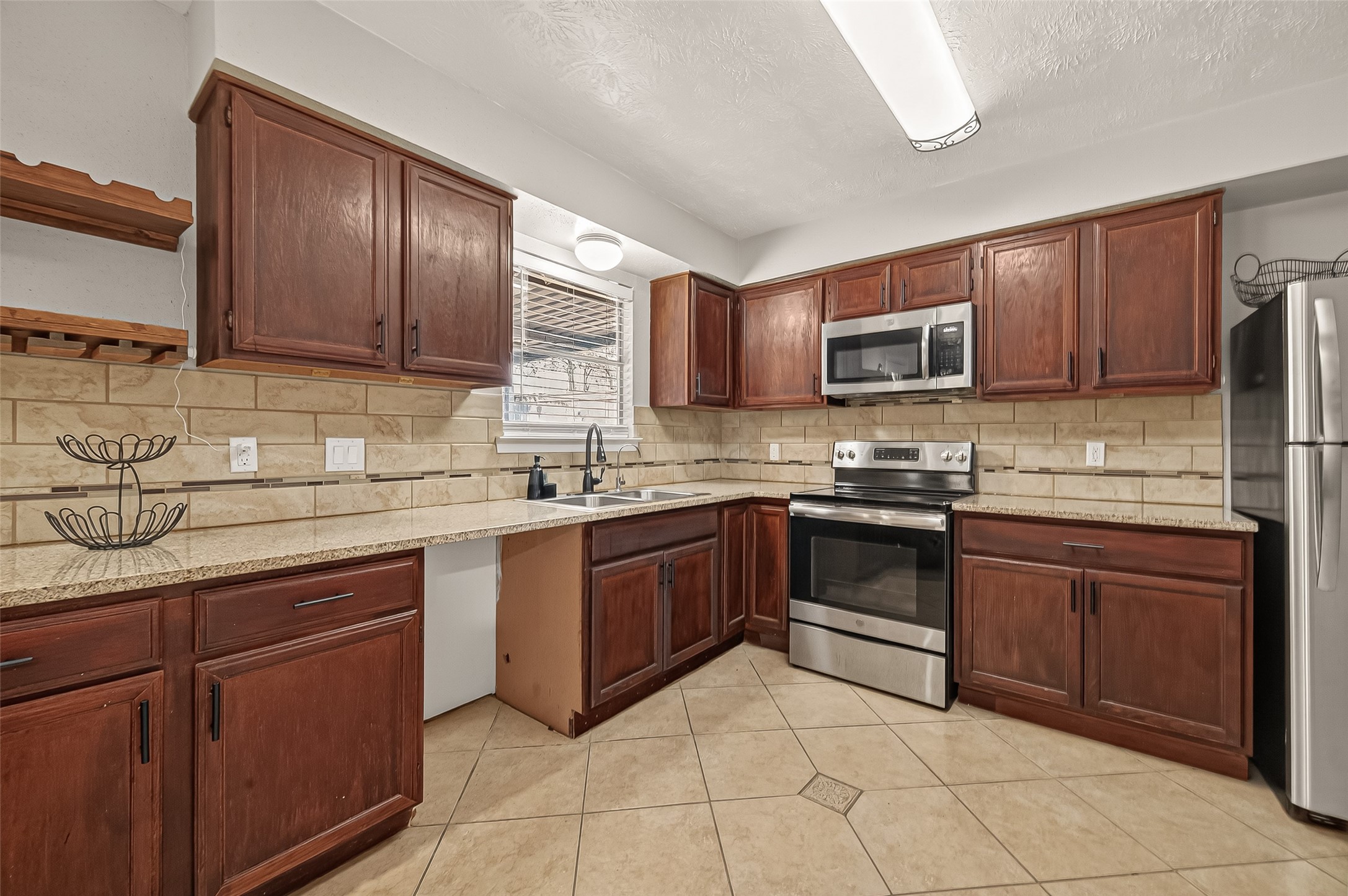 1407 Somercotes Lane Channelview, TX 77530 - Photo 8 of 28 a kitchen with stainless steel appliances granite countertop wooden cabinets a stove top oven a sink and dishwasher