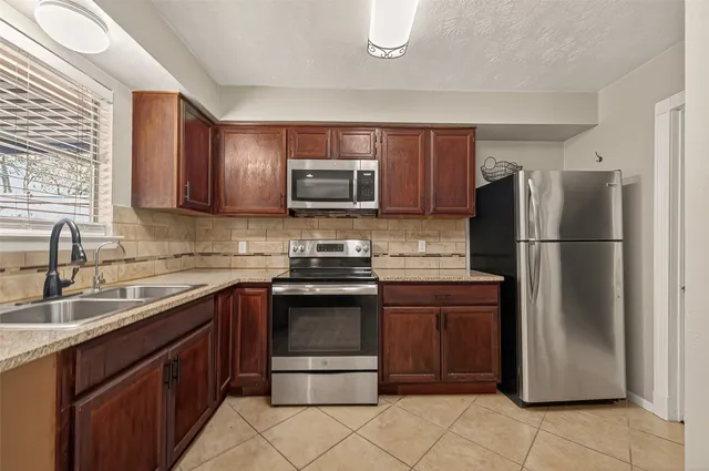 a kitchen with a sink stove and microwave