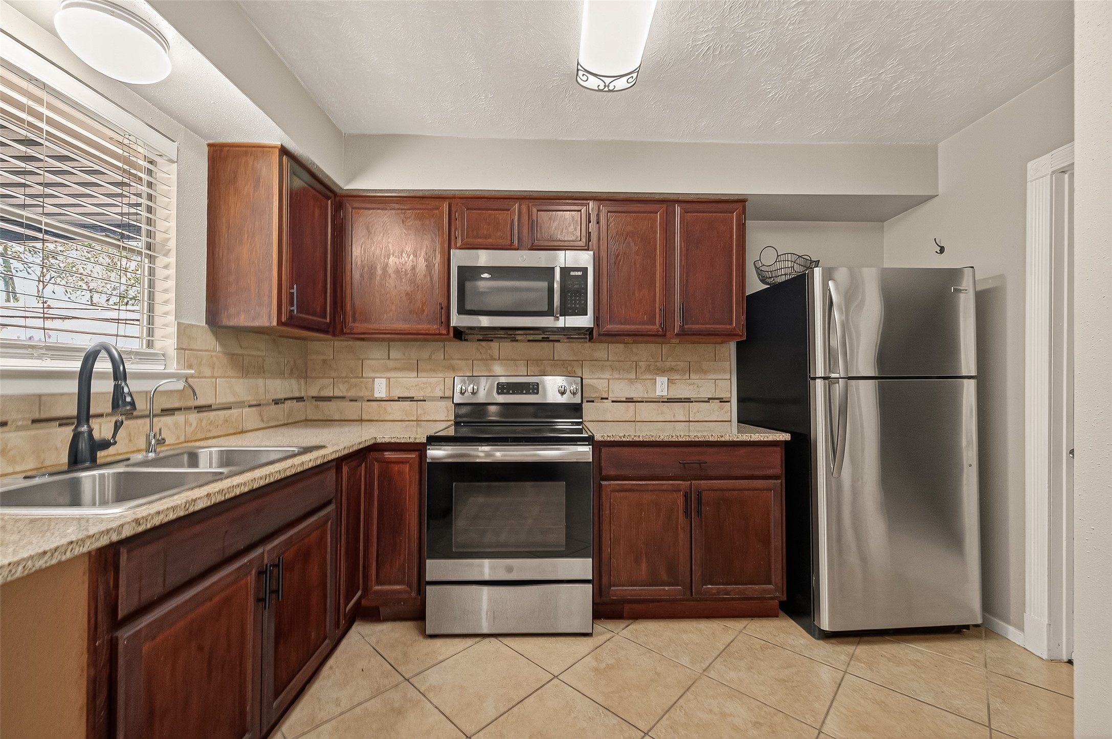 1407 Somercotes Lane Channelview, TX 77530 - Photo 10 of 28 a kitchen with stainless steel appliances granite countertop a refrigerator stove a sink and dishwasher