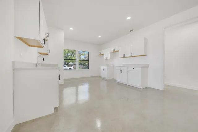 a view of an empty room with kitchen appliances and cabinets