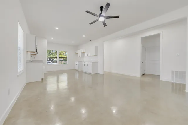 a view of empty room with wooden floor and ceiling fan