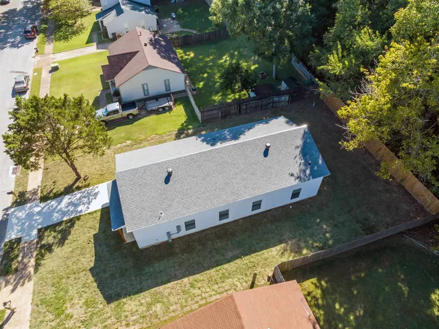 an aerial view of a house with swimming pool and a yard