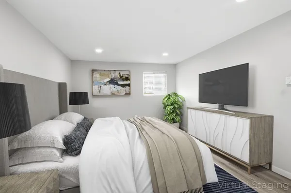 a bedroom with a large bed and a flat screen tv