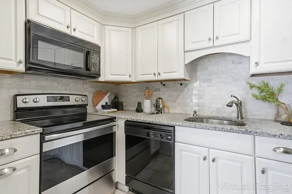 a kitchen with granite countertop white cabinets and white appliances