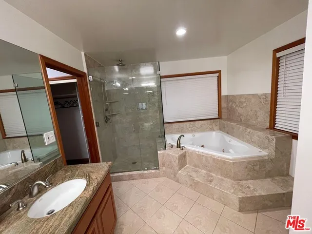 a bathroom with a tub sink and mirror