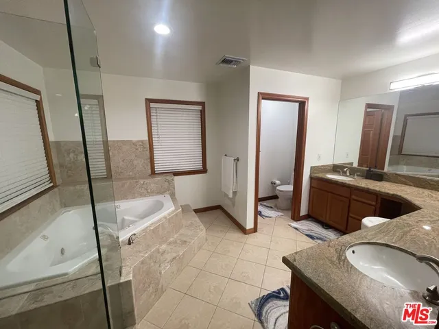 a spacious bathroom with a granite countertop sink and a mirror