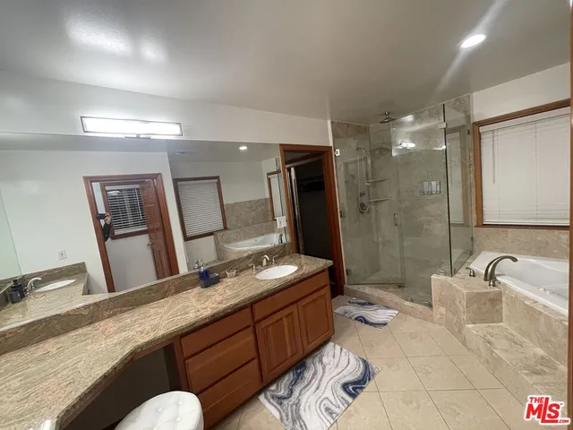 a spacious bathroom with a granite countertop sink and a mirror