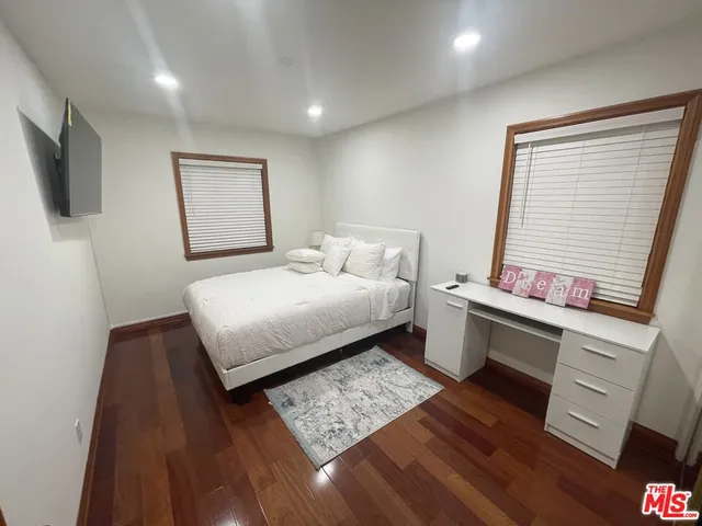 a bedroom with a bed and a flat screen tv