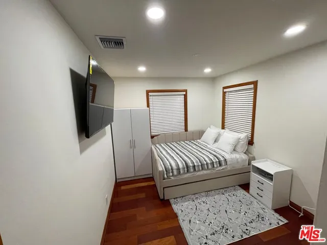 a bedroom with a bed and flat screen tv