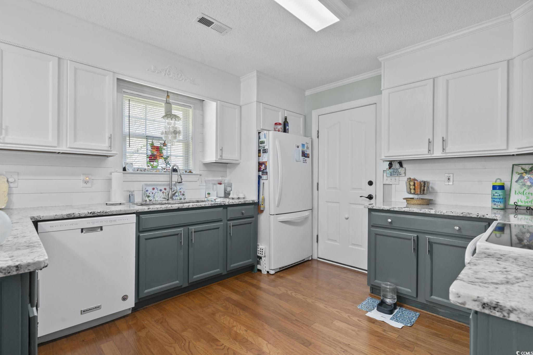 3607 Brampton Drive Myrtle Beach, SC 29588 - Photo 11 of 34 Kitchen featuring gray cabinets, light stone counters, a textured ceiling, and crown molding