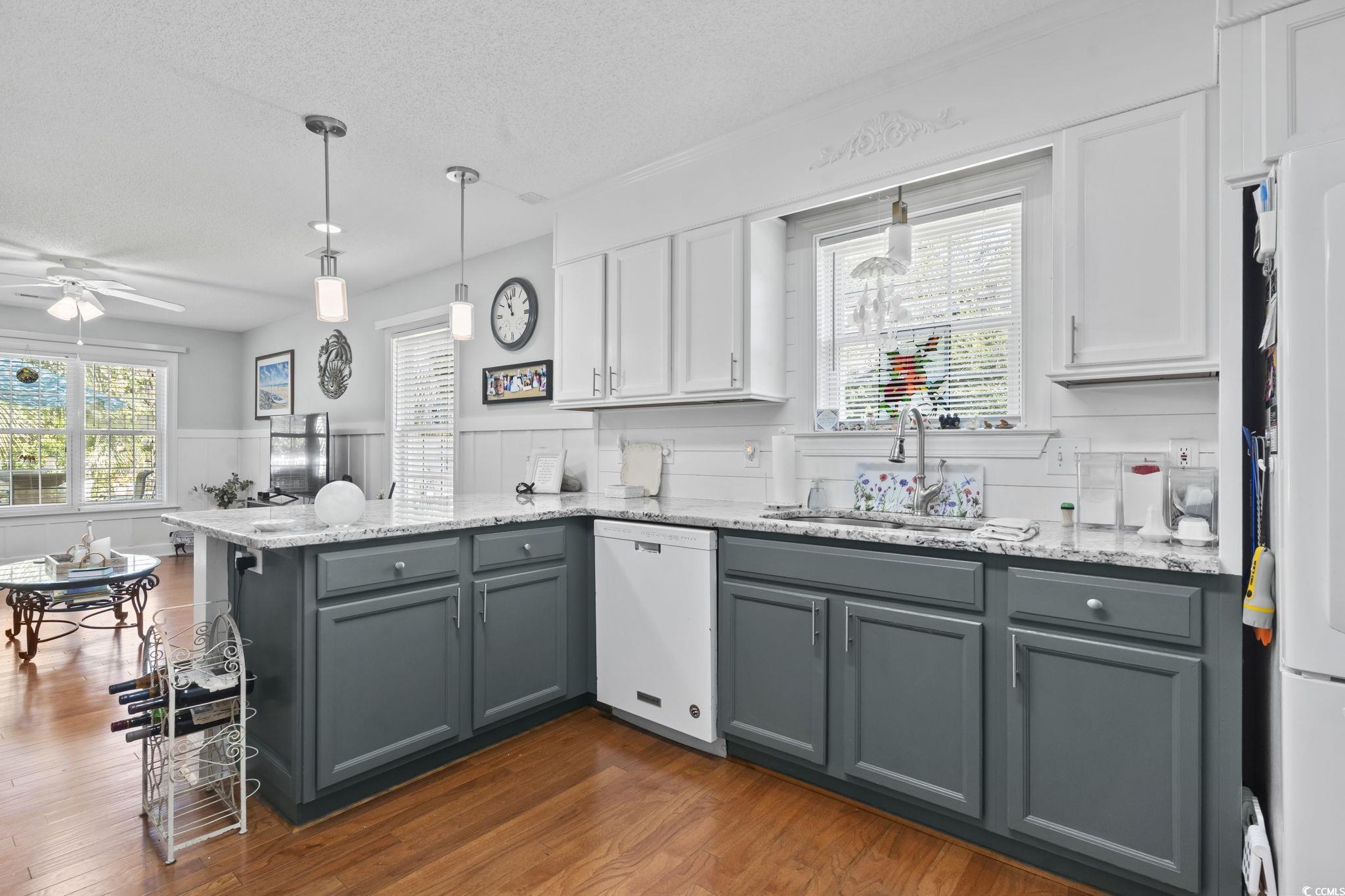 3607 Brampton Drive Myrtle Beach, SC 29588 - Photo 12 of 34 Kitchen with gray cabinetry, a peninsula, white cabinetry, hanging light fixtures, and a textured ceiling