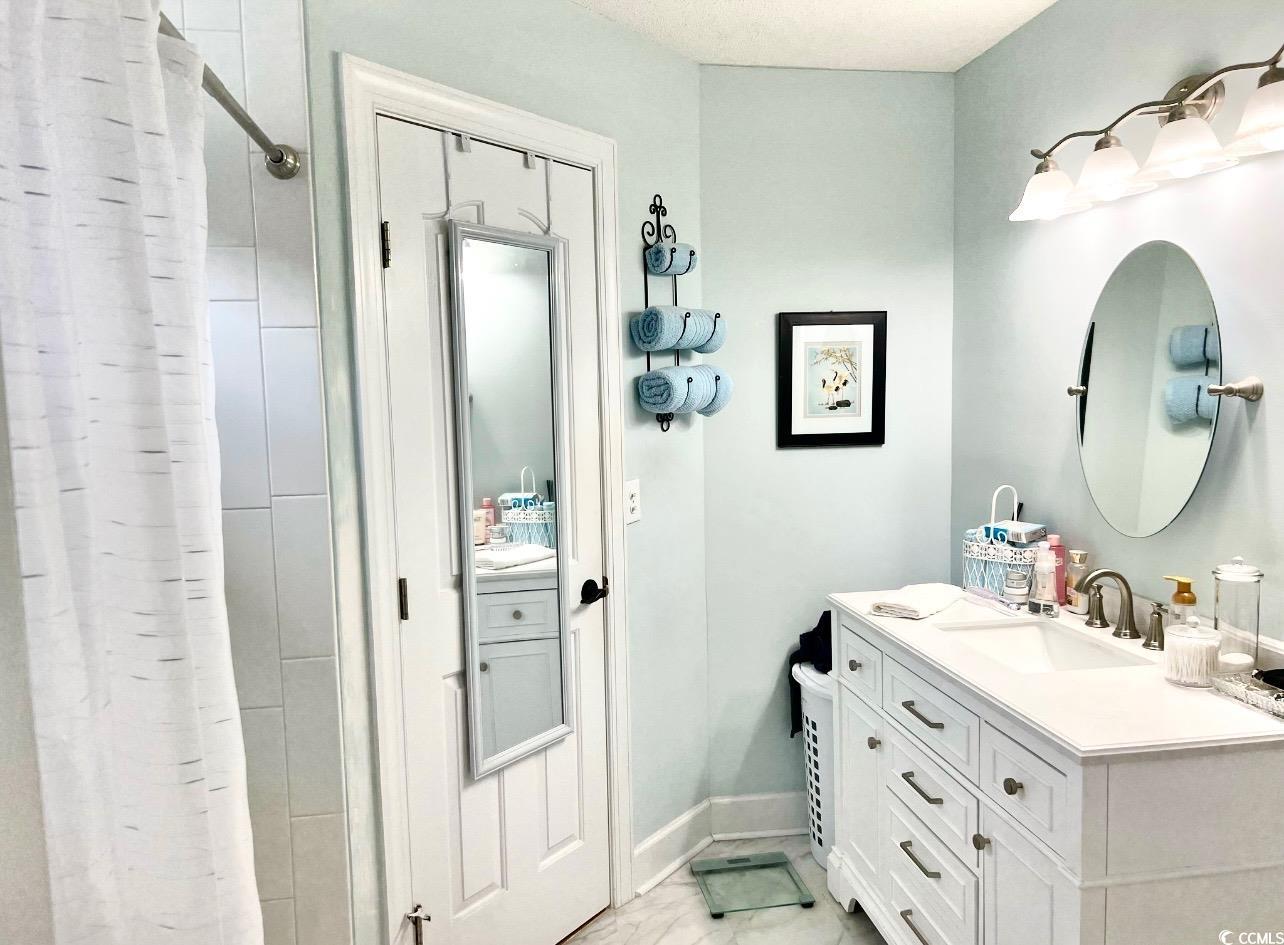 3607 Brampton Drive Myrtle Beach, SC 29588 - Photo 17 of 34 Bathroom featuring vanity, curtained shower, and light marble finish floors