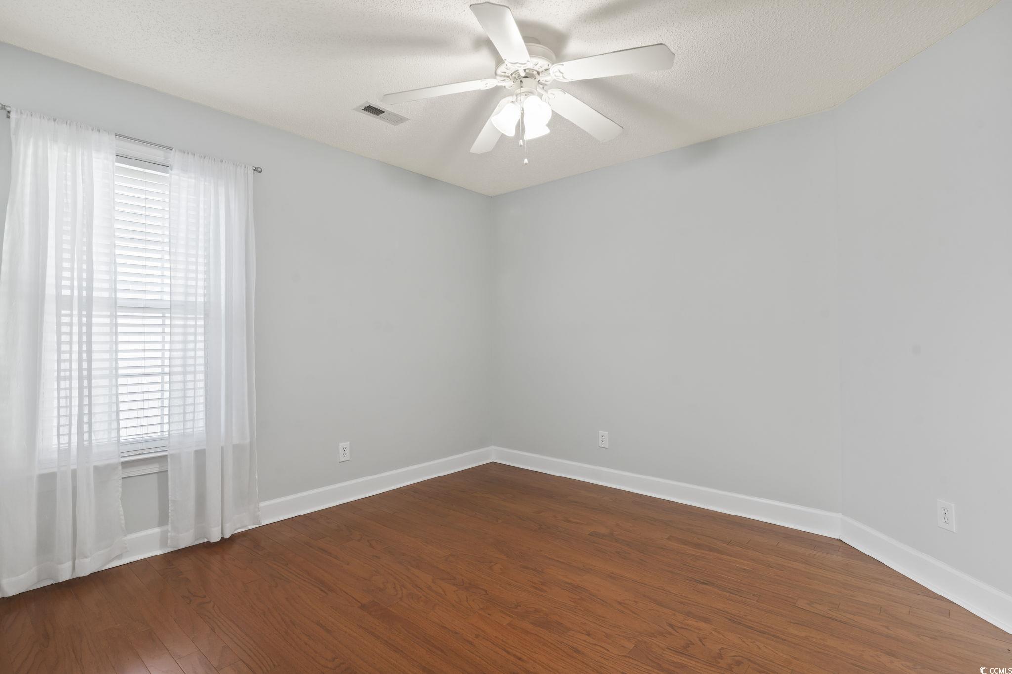 3607 Brampton Drive Myrtle Beach, SC 29588 - Photo 20 of 34 Spare room with dark wood-style floors, a textured ceiling, and a ceiling fan