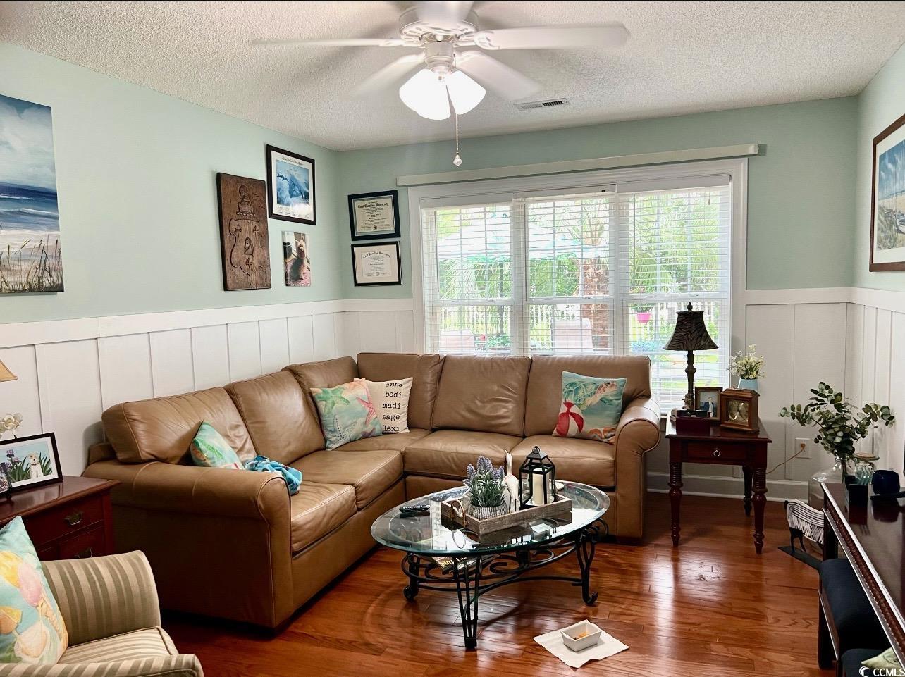 3607 Brampton Drive Myrtle Beach, SC 29588 - Photo 23 of 34 Living area with wood finished floors, wainscoting, a textured ceiling, ceiling fan, and a decorative wall