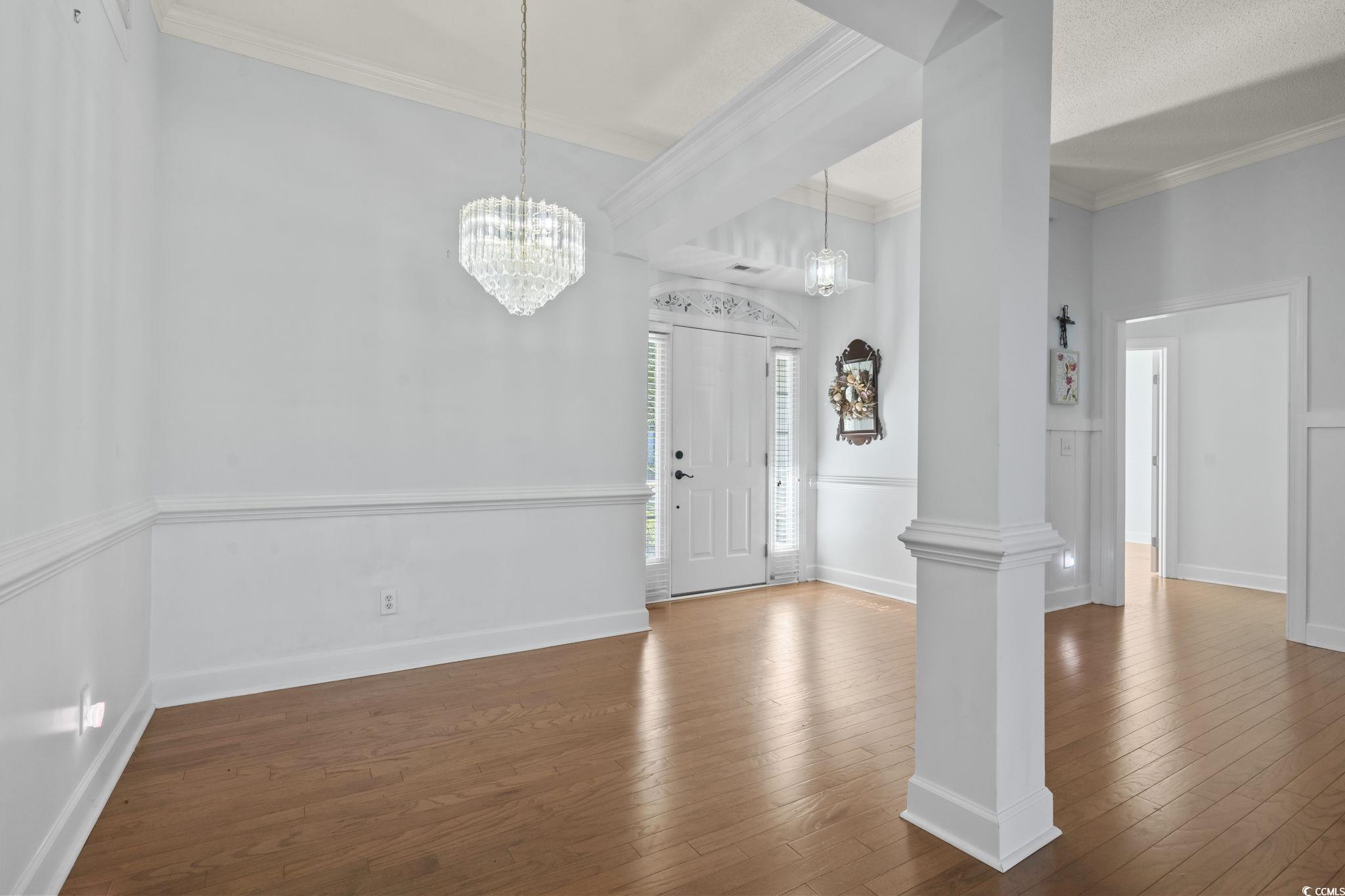 3607 Brampton Drive Myrtle Beach, SC 29588 - Photo 3 of 34 Entrance foyer featuring dark wood-style flooring, ornamental molding, and a chandelier