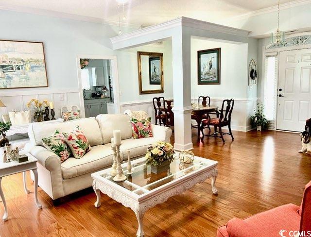 3607 Brampton Drive Myrtle Beach, SC 29588 - Photo 32 of 34 Living area with wood finished floors, crown molding, and a chandelier