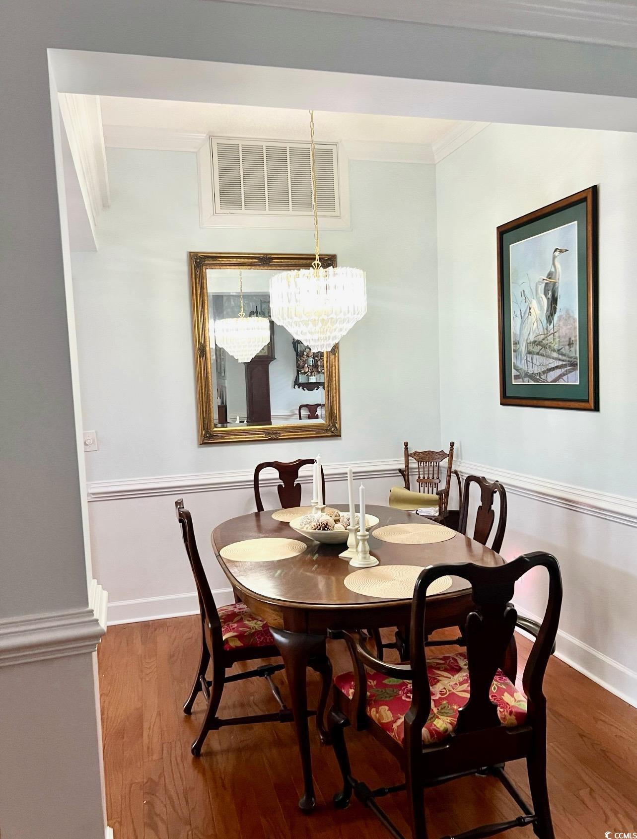 3607 Brampton Drive Myrtle Beach, SC 29588 - Photo 5 of 34 Dining room with dark wood-style flooring, crown molding, and a chandelier