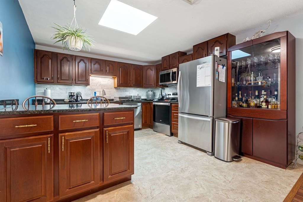 135 Forest Street, Unit W2 Saugus, MA 01906 - Photo 1 of 23 a kitchen with stainless steel appliances granite countertop a refrigerator a sink a stove a microwave and island