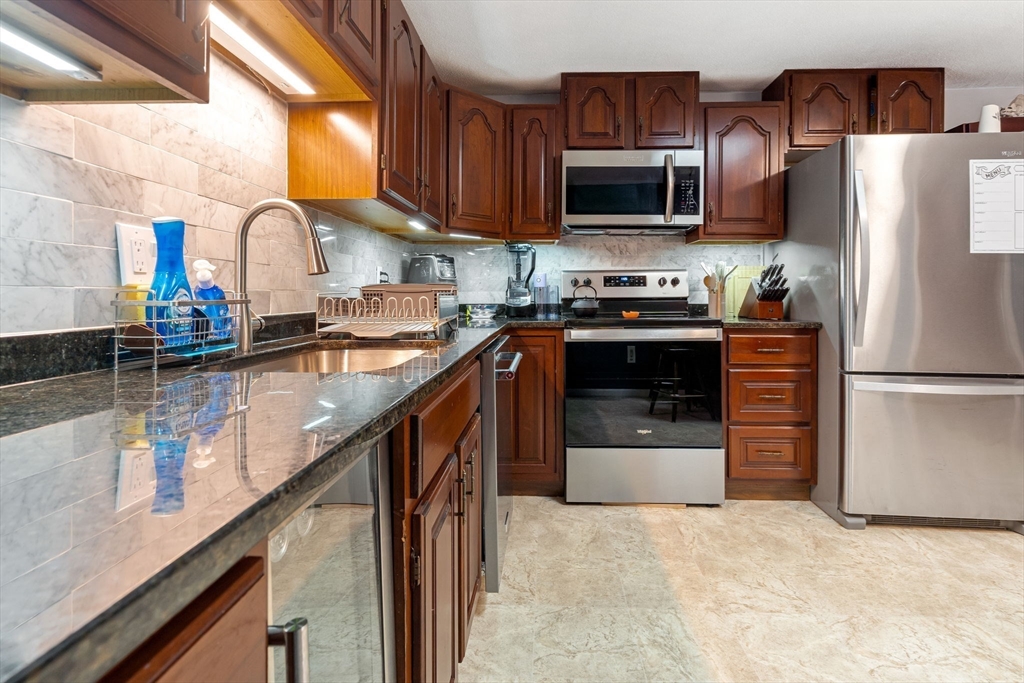 135 Forest Street, Unit W2 Saugus, MA 01906 - Photo 3 of 23 a kitchen with stainless steel appliances granite countertop a stove a sink and a refrigerator