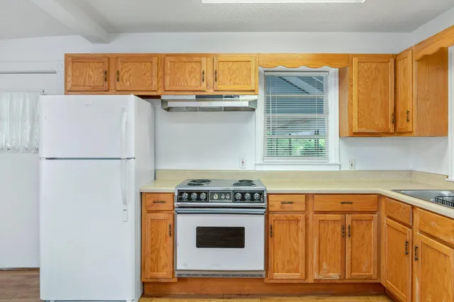 a kitchen with granite countertop a stove and a refrigerator