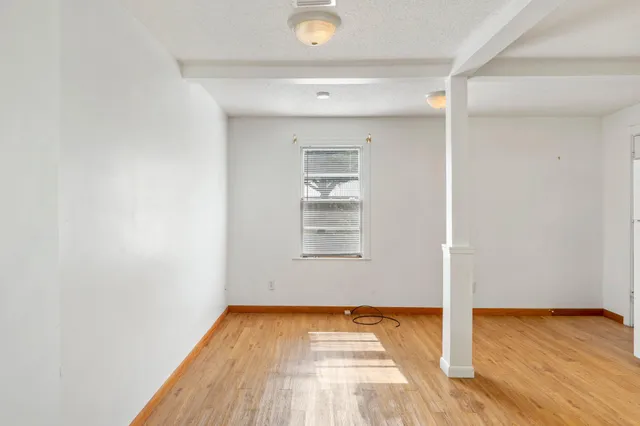 a view of a room with wooden floor and window