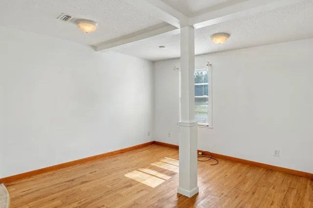 a view of empty room with wooden floor