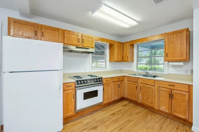 a kitchen with stainless steel appliances granite countertop a stove a sink and a refrigerator