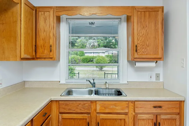 a kitchen with stainless steel appliances white cabinets and a window