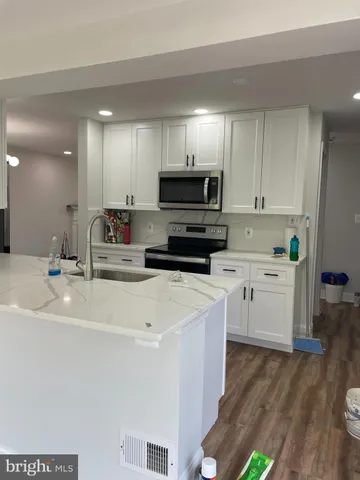 a kitchen with stainless steel appliances a stove a sink a microwave and cabinets