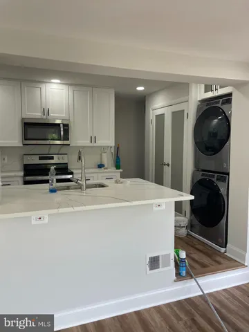 a view of a kitchen with sink washer and dryer