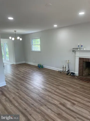an empty room with wooden floor and fireplace